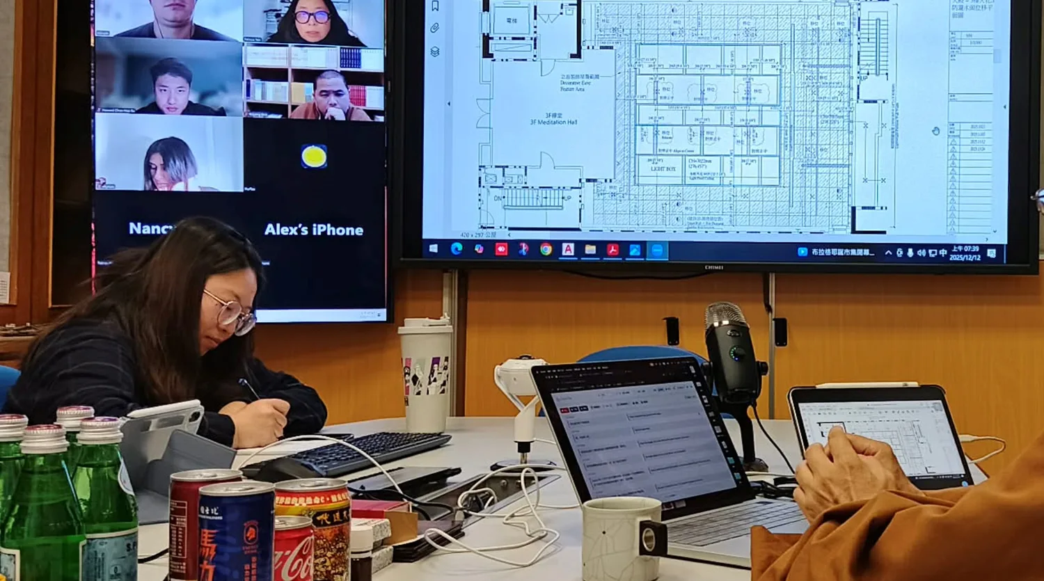 A cross-border design review: architectural floor plans and a remote-participant grid on the main screen, with Orato Flow translating on a laptop.