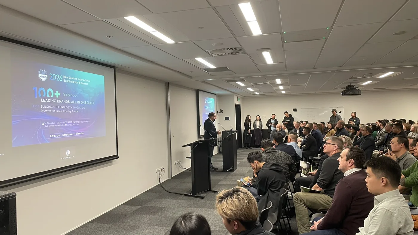 A full training room at Mitre 10’s Albany support centre during the Auckland launch of the 2026 NZCBIA Building & Construction Report, with a presenter at the lectern and a slide on the projector screen.